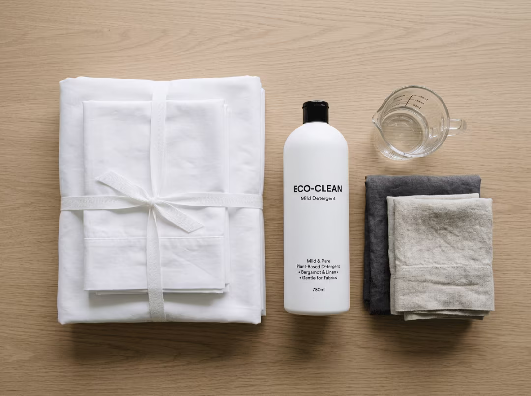 Folded white sheets with laundry care items Folded white sheets with laundry care items