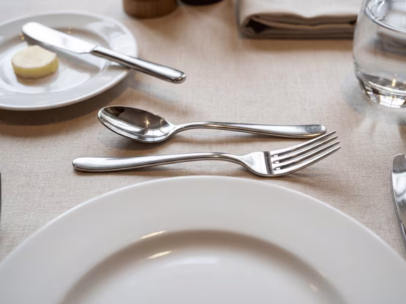 Dessert fork and spoon above the plate with a butter knife Dessert fork and spoon above the plate with a butter knife